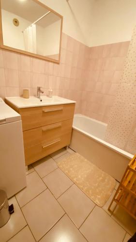 une salle de bain avec un lavabo, une baignoire et un miroir dans l'établissement Cosy 3pièces à 5min de la plage, à Cannes