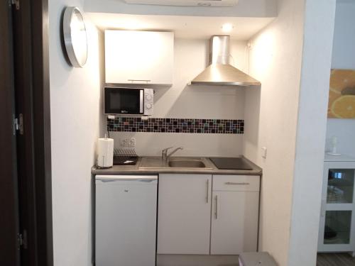 a small kitchen with white cabinets and a sink at Cap de Mar in Alcudia