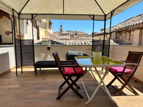 a table and chairs on a balcony with a view at Apartamento Canónigo - terraza con vistas in Toledo