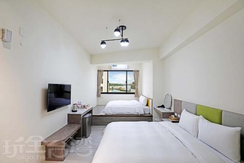 1 dormitorio blanco con 1 cama y TV en Happy Dragon Homestay en Yuchi