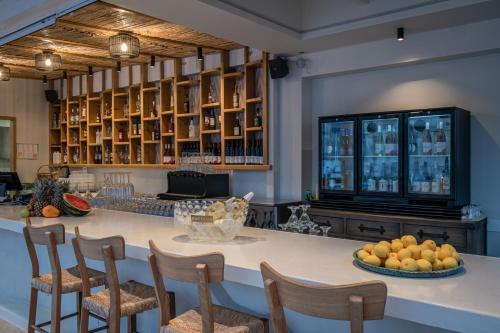 a kitchen with a large island with chairs and fruit on a counter at Parthenis Beach, Suites by the Sea in Malia