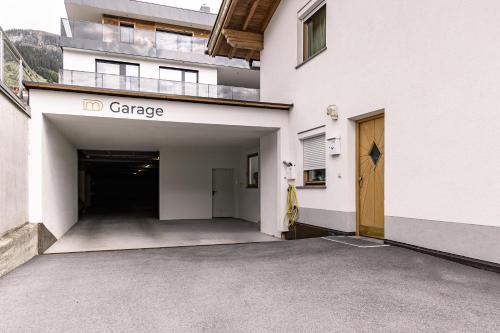 an empty parking garage in a white building at DAS MORITZ- Fine Living Apartments in Nauders