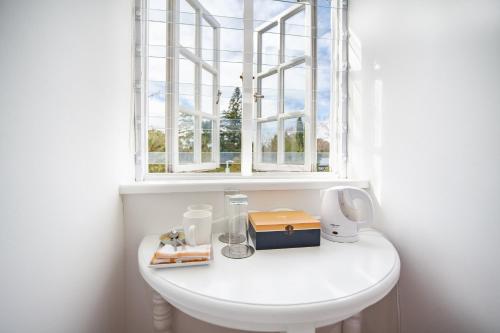 a bathroom with a white sink with a window at Cosimi Guest House in Durbanville
