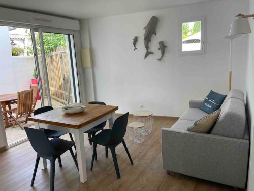 a living room with a couch and a table and chairs at Maison de vacances La Flotte 00491UI in La Flotte