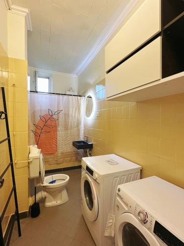 Un baño con lavadora y un inodoro. en 2 Schlafzimmer WaschenSpülmaschine, en Duisburg