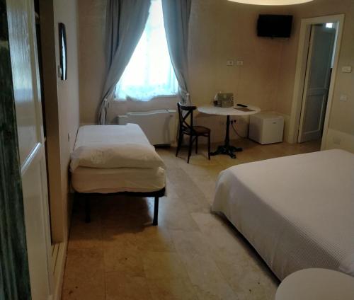 een kamer met 2 bedden, een tafel en een raam bij Hotel & Resort Lunatenuta in Mondragone