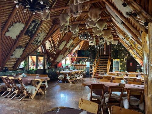モイエチウ・デ・ジョスにあるPensiunea La Moganの木製の天井が特徴のレストラン(テーブル、椅子付)