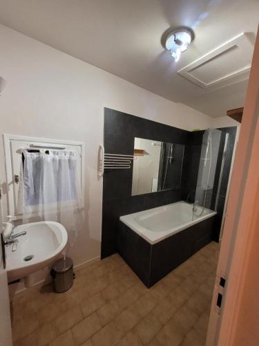 une salle de bain avec une baignoire et un lavabo dans l'établissement Maison T3 avec jardin (8pers), à La Crau