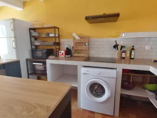 a kitchen with a washing machine under a counter at Maison T3 avec jardin (8pers) in La Crau