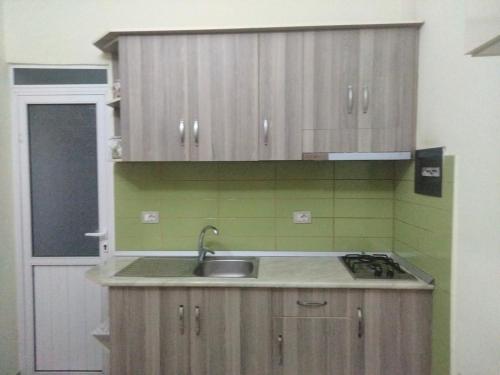 a kitchen with wooden cabinets and a sink at Apartment in Vlorë