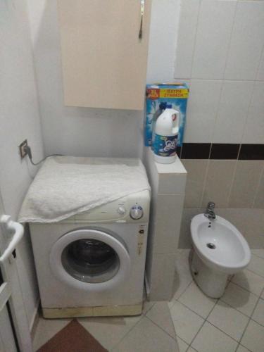 a small bathroom with a washing machine and a toilet at Apartment in Vlorë
