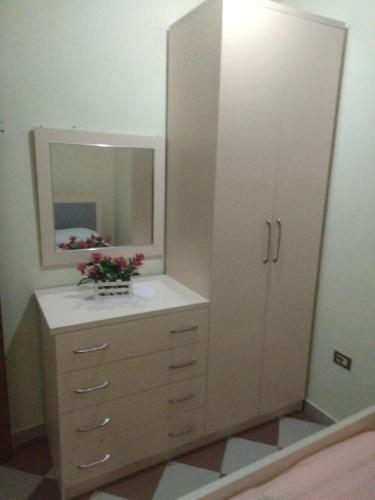 a bathroom with a dresser with a mirror at Apartment in Vlorë