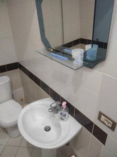 a bathroom with a sink and a toilet and a mirror at Apartment in Vlorë