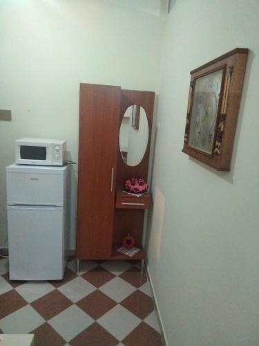 a kitchen with a microwave and a refrigerator and a mirror at Apartment in Vlorë