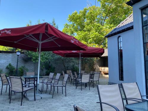 a patio with tables and chairs and an umbrella at Level Up Hotel & Restaurant in K'obulet'i