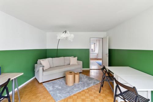 a living room with a white couch and green walls at Beautiful Boutique Apartment DRAHTZUG8 in Zürich