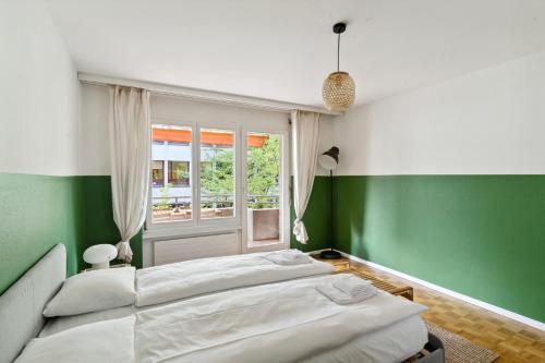 a bedroom with green and white walls and a bed at Beautiful Boutique Apartment DRAHTZUG8 in Zürich