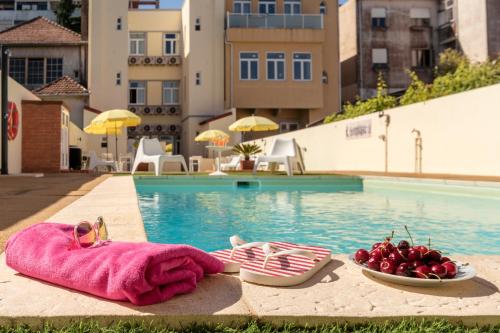 a pool with two towels and a bowl of fruit next to a pool at 733 Costa Cabral Metro Residence in Porto