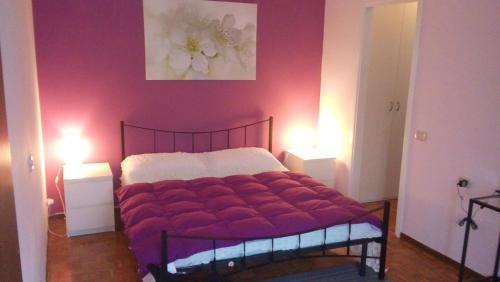 a bedroom with a bed with two lights on at Casa Vacanze Orchidea CIR0347AT00249 in Parma