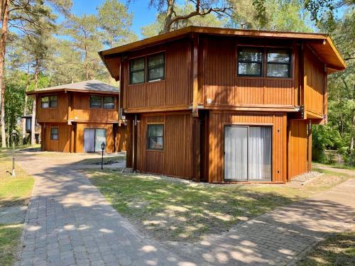 a large wooden house with a driveway at Hotel Residenz WALDOASE in Ahlbeck