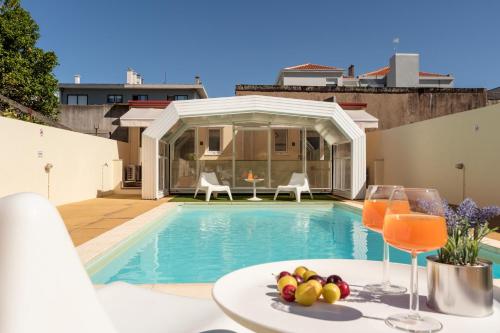 a villa with a swimming pool and a table with a plate of fruit at 731 Costa Cabral Metro Residence in Porto