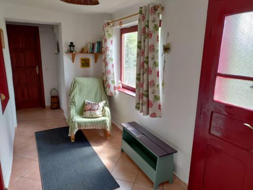 FelsőmarácにあるZsuzsanna Házの緑の椅子と窓のあるリビングルーム