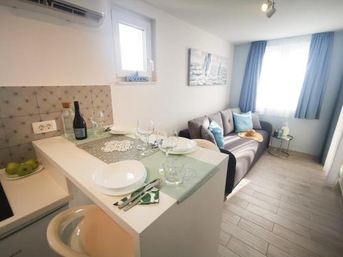 uma cozinha e sala de estar com uma mesa e um sofá em Rita Apartments - Sea-view apartment 2plus1 em Tučepi