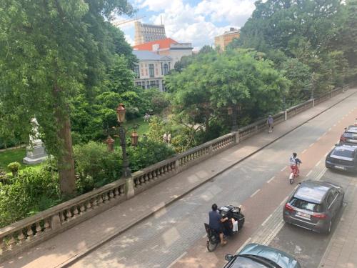 a view of a road with cars and people on motorcycles at Botanique Suites AirBnB, Antwerp in Antwerp