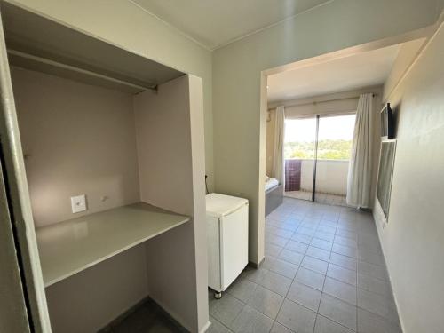 an empty room with a refrigerator and a window at Hotel Viena in Taguatinga