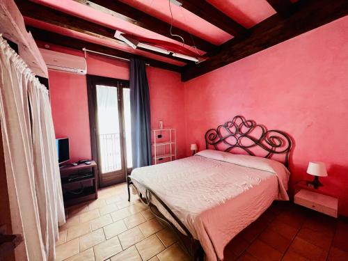 a bedroom with a bed in a red wall at Marnabianca Apartment in Realmonte