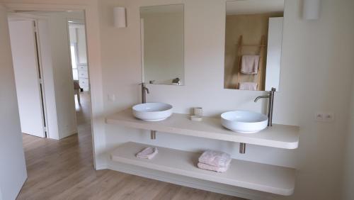 Baño blanco con 2 lavabos y espejo en Villa Le Renard, en Knokke-Heist