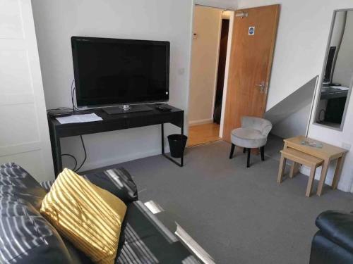 - un salon avec un canapé et une télévision dans l'établissement Fabulous 4 bed 4 bath right by Luton Airport, à Luton