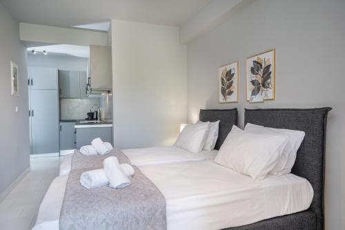 a bedroom with two beds with white pillows at Mary's Studios & Apartment in Sami