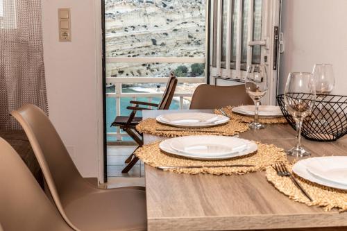 una sala da pranzo con tavolo, sedie e finestra di Emmanouela Apartment a Mátala