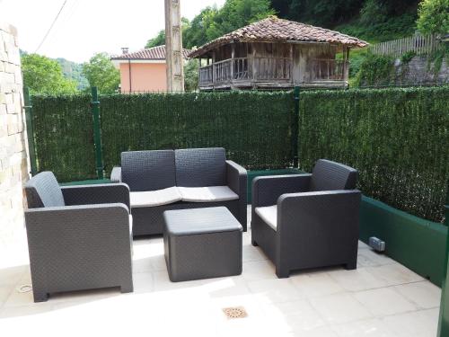 a patio with chairs and a table and a fence at Casa gueli in Cangas de Onís