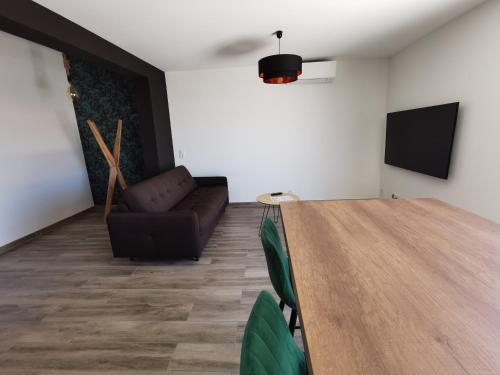 einen Konferenzraum mit einem Tisch und einem Sofa in der Unterkunft AS22351 - P3 au 2ème et dernier étage dans une résidence neuve en Centre Ville in Le Grau-du-Roi