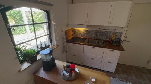 una cocina con armarios blancos y una encimera con ventana en Stort rymligt boende med två sovrum och pentry i lantlig miljö en Höllviken