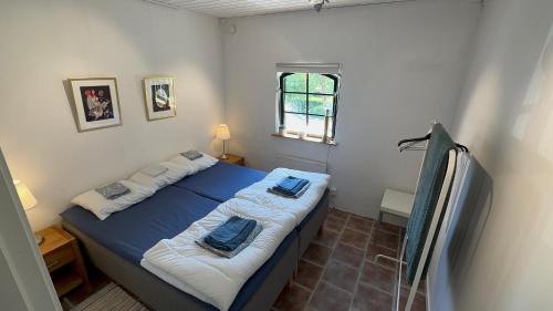 a bedroom with a bed with two towels on it at Stort rymligt boende med två sovrum och pentry i lantlig miljö in Höllviken