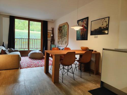 a living room with a wooden table and chairs at Hostdomus - Sansicario R21 in Cesana Torinese
