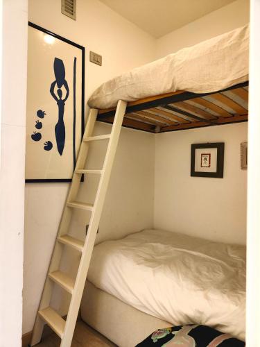 a bunk bed with a ladder next to a bed at Hostdomus - Sansicario R21 in Cesana Torinese