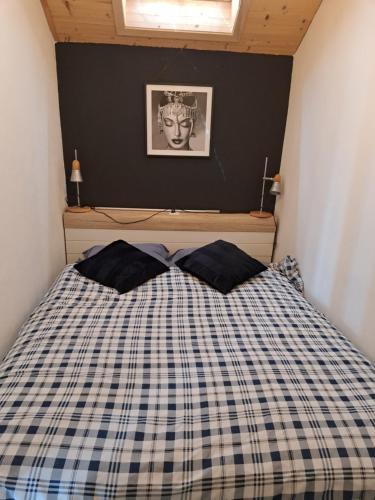 a bedroom with a bed with a checkered blanket at Charmante maison au coeur du Lavaux, Cully, cuisine, WiFi, Les Echalas in Cully