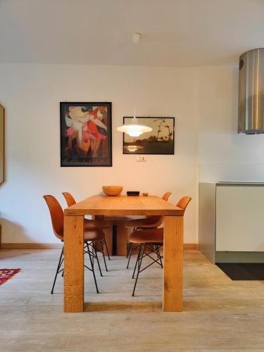 a dining room with a wooden table and chairs at Hostdomus - Sansicario R21 in Cesana Torinese