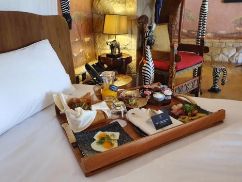un vassoio di cibo sopra un letto di Nofa Riyadh, A Radisson Collection Resort a Ţibrāk