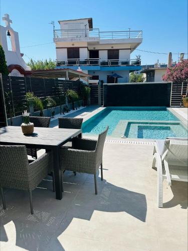 a patio with a table and chairs next to a swimming pool at Flev's Luxury House with pool in Kremasti
