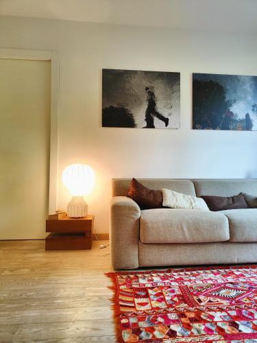 a living room with a couch and a lamp at Hostdomus - Sansicario R21 in Cesana Torinese