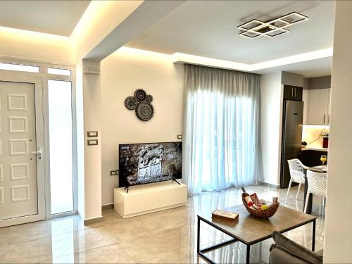 a living room with a tv and a table at Flev's Luxury House with pool in Kremasti