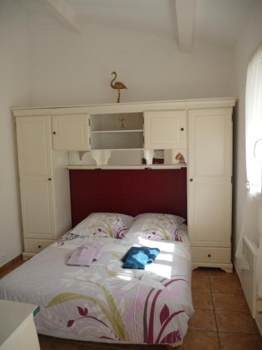 ポルト・ヴェッキオにあるCarestellaのベッドルーム1室(ベッド1台、ヘッドボード、白いキャビネット付)