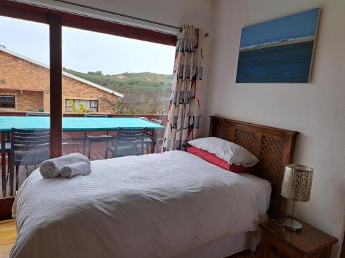 a bedroom with a bed and a large window at Sundays River Mouth Guesthouse in Colchester