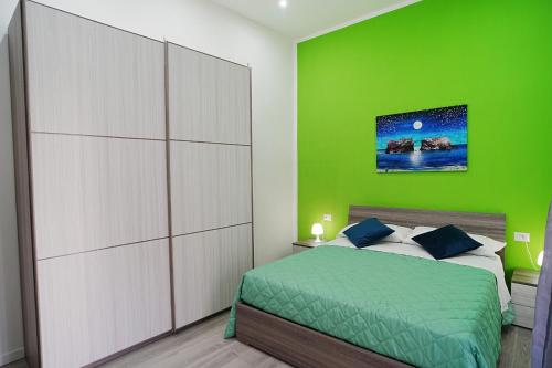 een slaapkamer met een groene muur en een bed bij Just Like Home in Napels