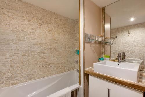 a bathroom with a sink and a shower and a tub at Vila De La Mar & Spa in Saintes-Maries-de-la-Mer